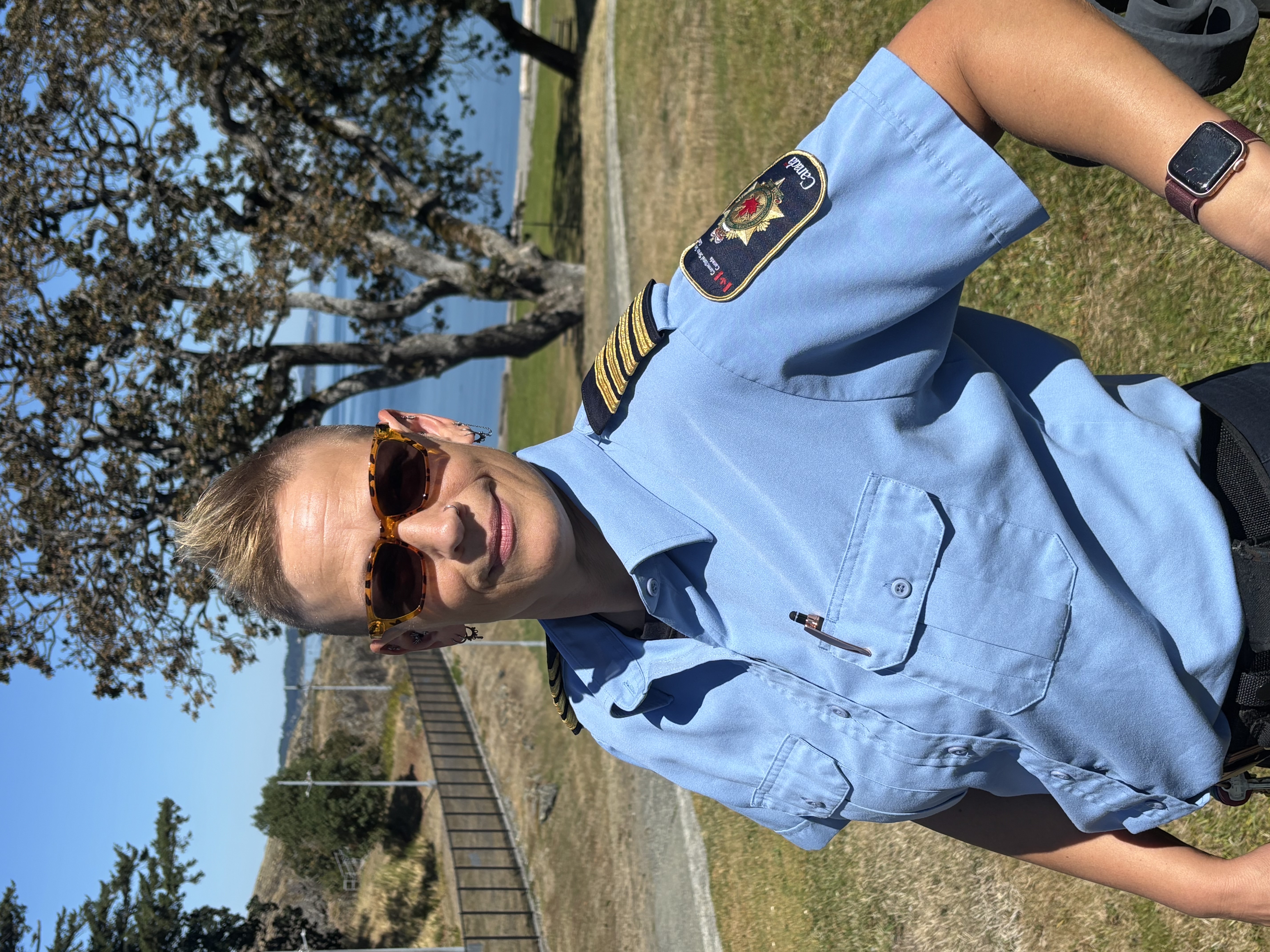 Dana Hackl à l’extérieur qui porte un uniforme de gestionnaire correctionnelle bleu pâle et des lunettes de soleil