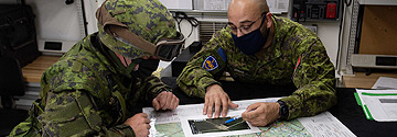 Two military personnel observing a map.