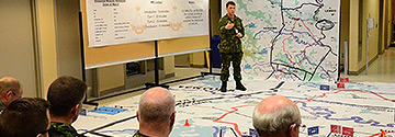 Instructor talking to students standing on a room sized map