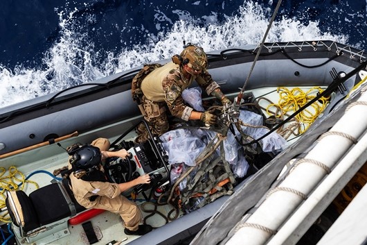 HMCS Whitehorse crewmembers transport seized drugs to a United States Coast Guard cutter during Operation CARIBBE on 13 April 2019.