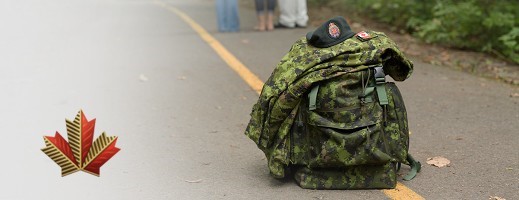 Picture shows an army pack with an army camo jacket and beret on top on the road