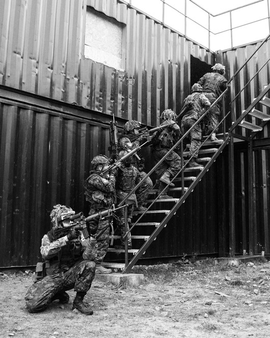 Canadian Armed Forces members from NATO's eFP Battle Group Latvia, participate in Exercise URBAN REAPER in the training area of Camp Ādaži, Latvia, 17 October 2019. The black and white photo shows 6 soldiers on a staircase breaching a building 