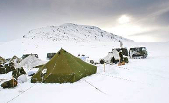 Un camp militaire établi sur un terrain enneigé.