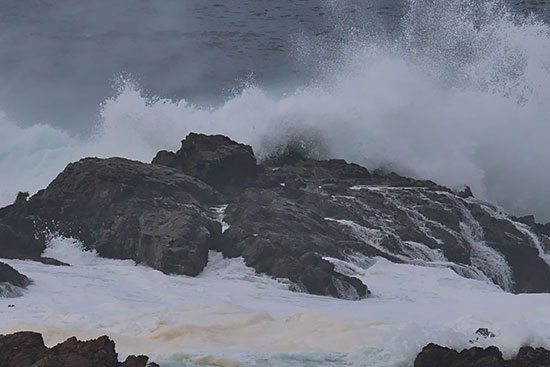 Waves crash on a rocky shore.