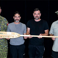 LGen Kelsey presenting an award to team Verdun Canoe Club featuring Lcol Cedric Bowes-Lyon, Maj Derric Bowes-Lyon, and Sgt Darrel Bowes-Lyon, the team that won first place in the race as well as raisinig the most funds.