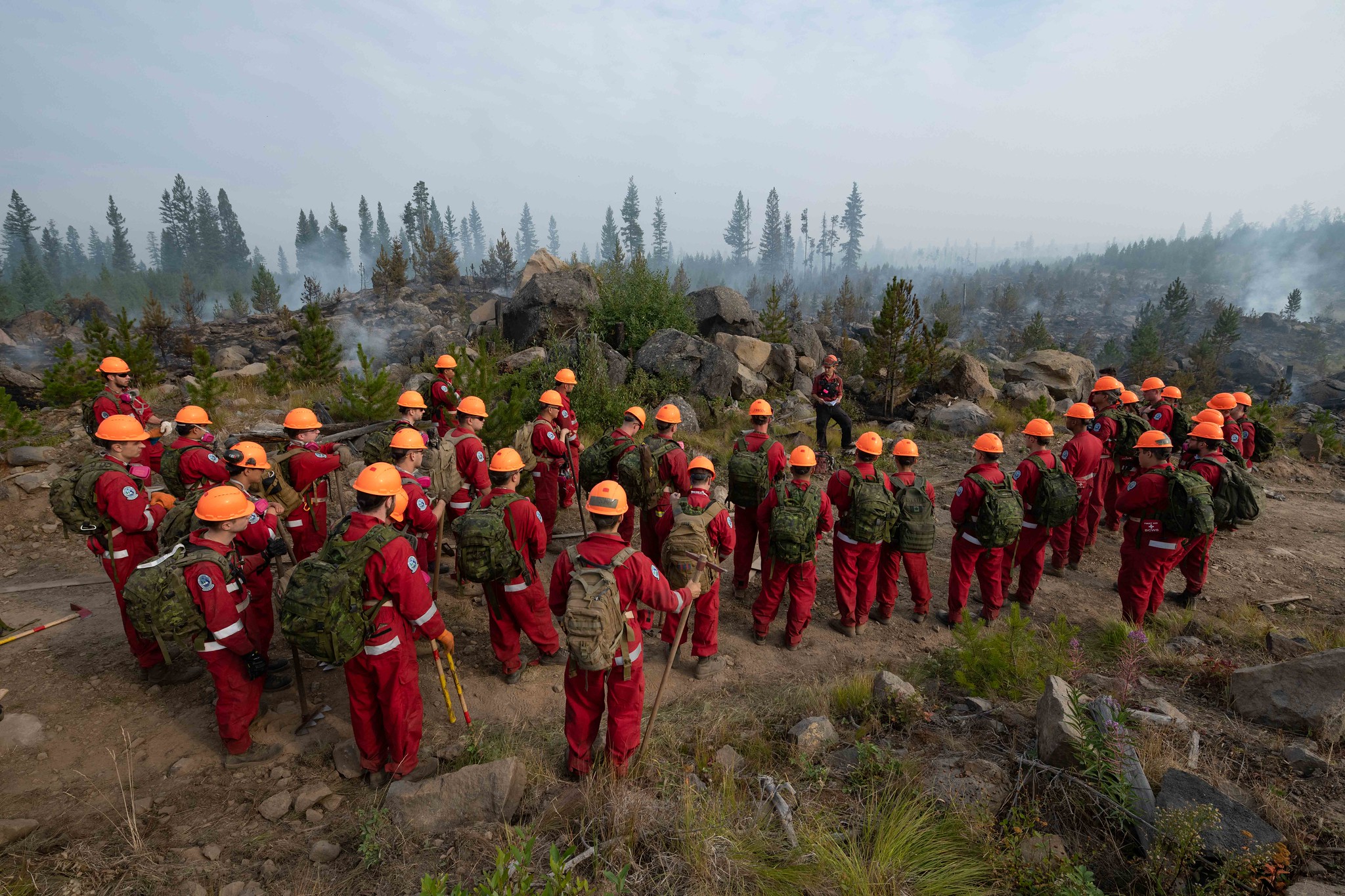 Des membres de la Compagnie d’intervention nationale (CIN) et des réservistes provenant des 38e, 39e et 41e Groupes-brigades du Canada de l’Ouest canadien procèdent à des opérations de lutte contre les incendies de type 3 sous la supervision des services de lutte contre les feux de forêt de la Colombie Britannique (C. B.) lors de l’incendie à Flat Lake, près de 100 Mile House, en C. B., au cours de l’opération LENTUS, le 18 août 2021.