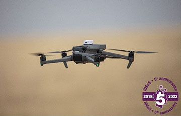 Un drone quadricoptère noir volant. Texte sur l’image : IDEeS 5e anniversaire. 2018-2023.