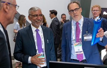 Two men in suits at a trade show