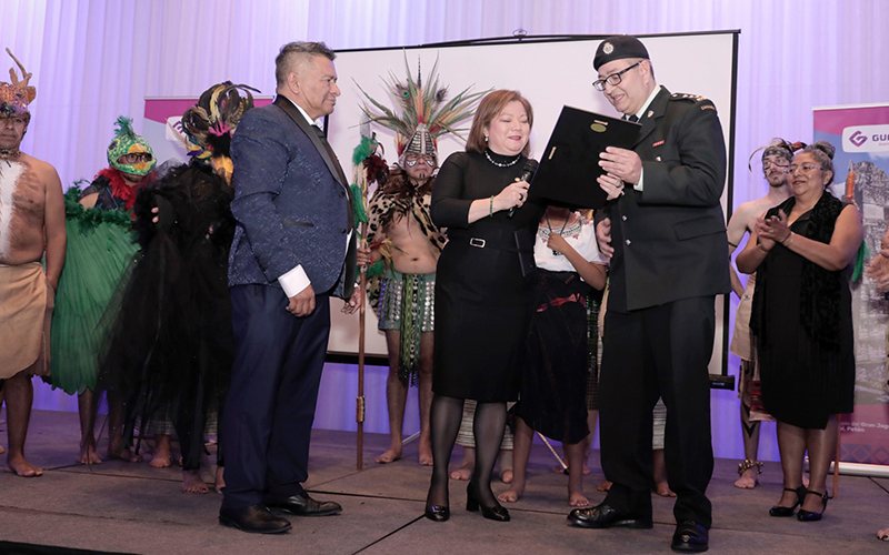 Capt Rey Garcia-Salas receives plaque from Julissa Hengstenberg Delgado