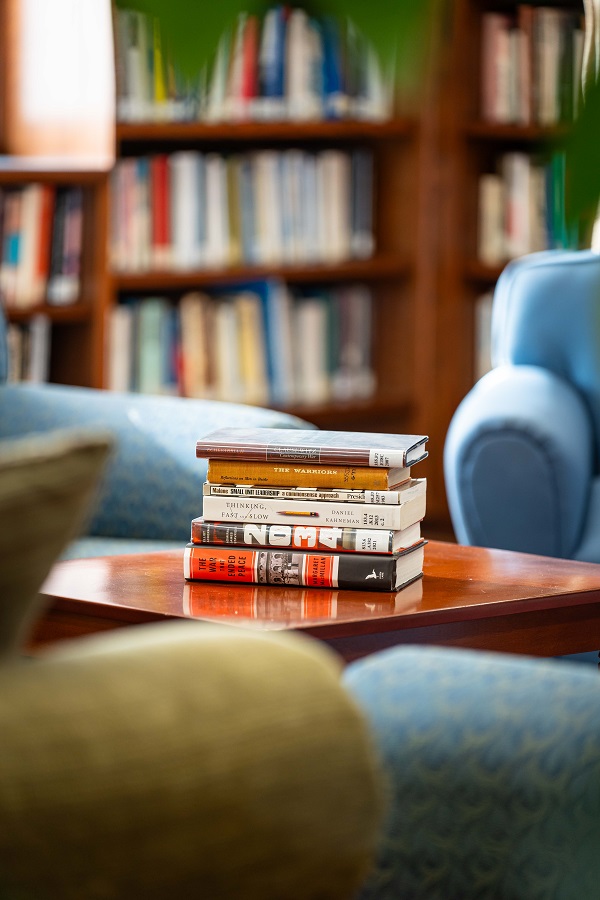 Une pile de livres déposée sur une table dans une bibliothèque.