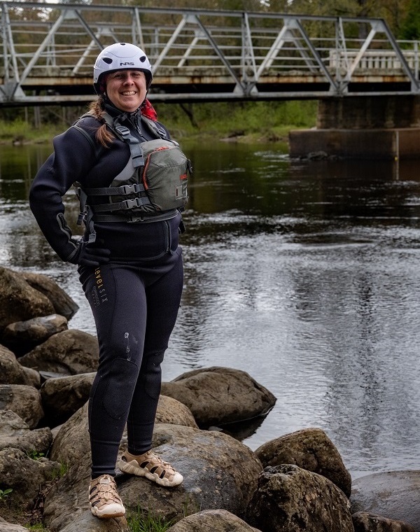 Warrant Officer Katherine Vick stands on the rocky banks of a river during the True Patriot Love Madawaska Training Camp.