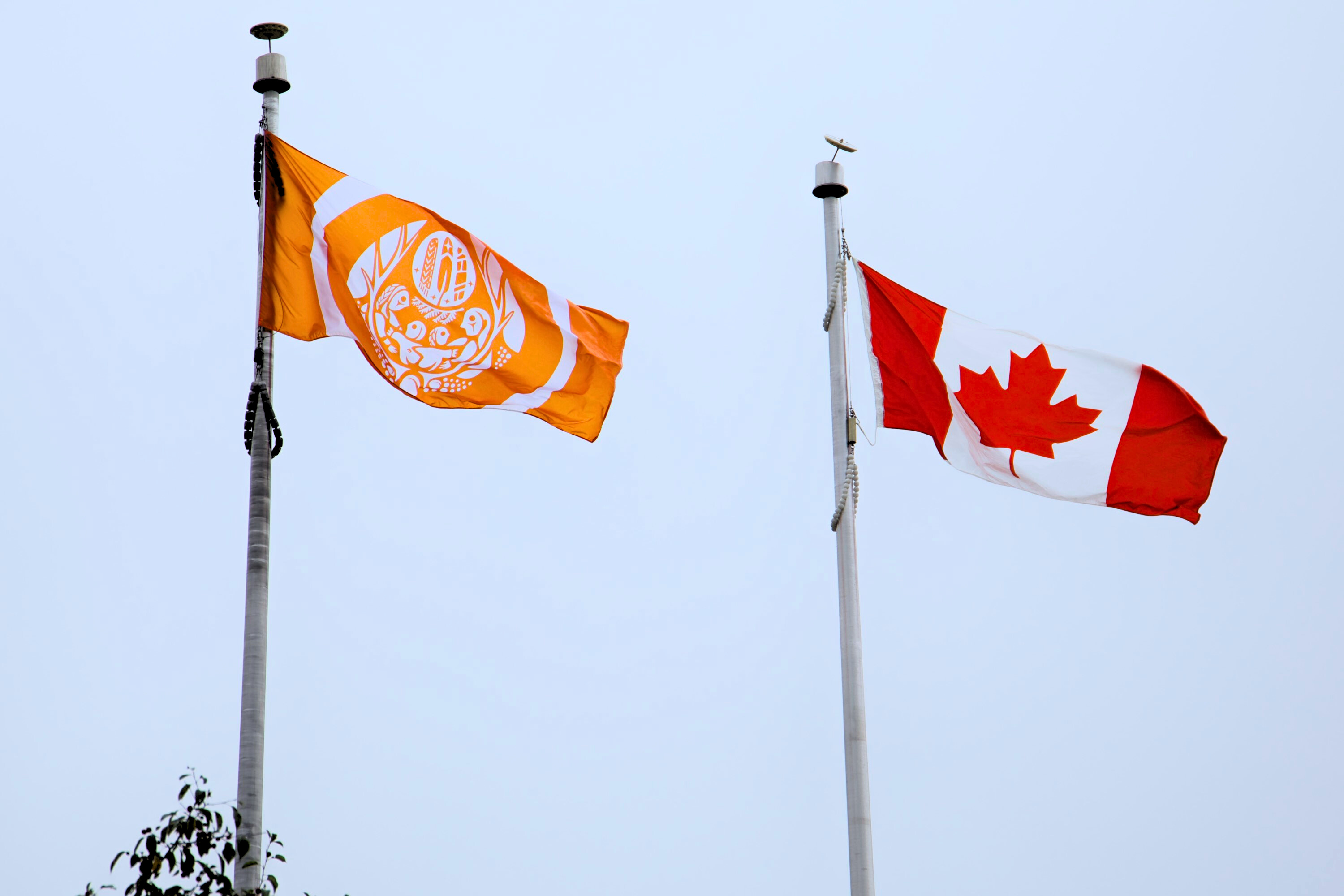 The Survivors’ Flag and the Canadian Flag are raised side by side on flagpoles during a ceremony at NDHQ Carling marking the National Day for Truth and Reconciliation.