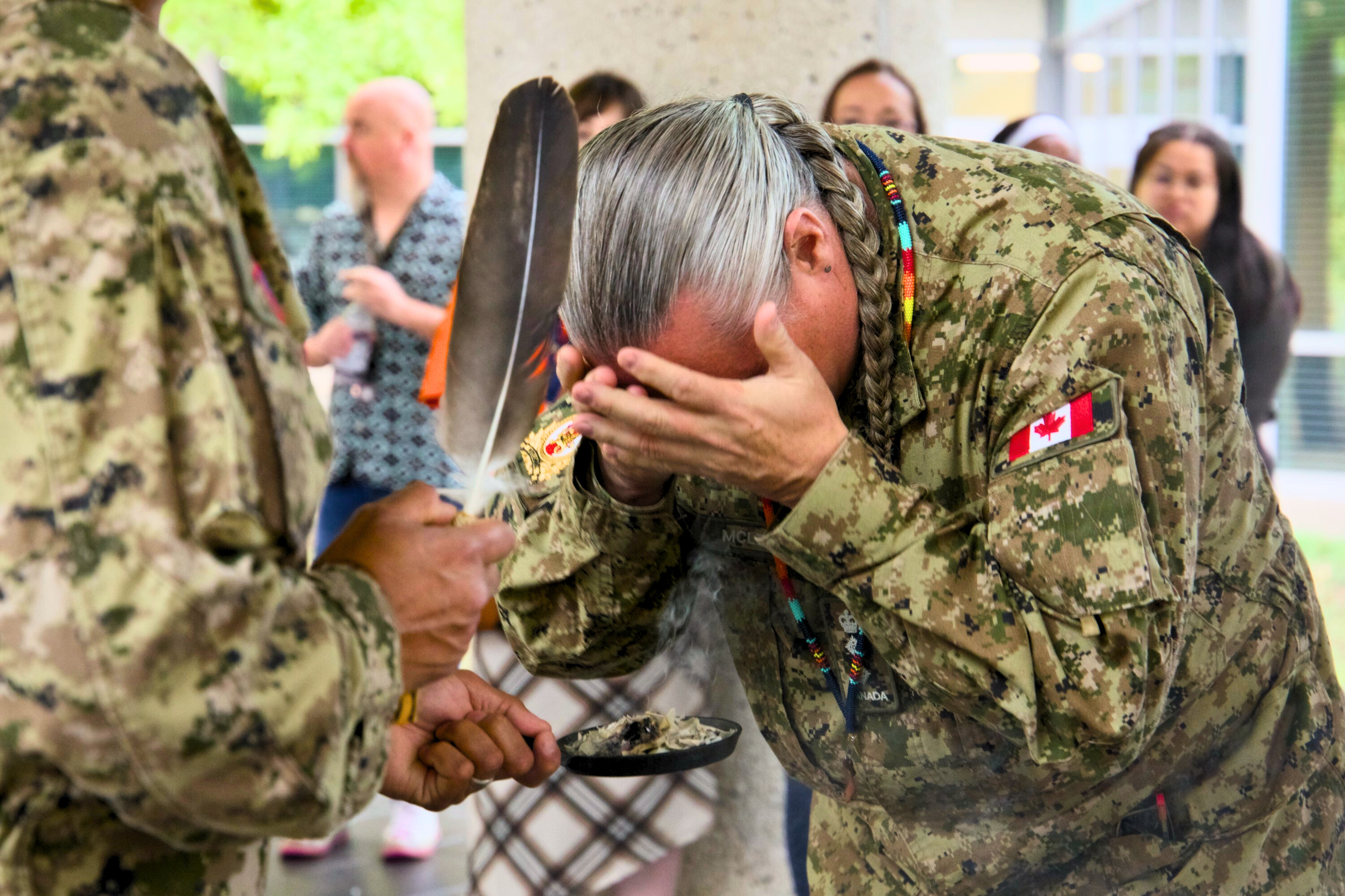 A member of the Canadian Armed Forces bows their head during a smudging ceremony held as part of the National Day for Truth and Reconciliation commemorations at NDHQ Carling.
