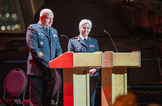 Two CAF members stand in front of two podiums.