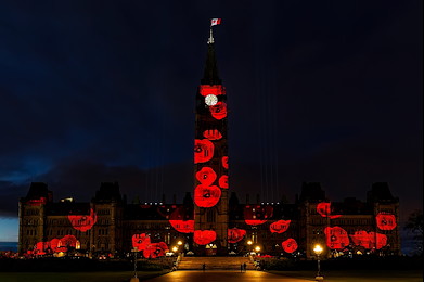 In the Glow of Gratitude: A landmark building illuminated with red circular lights, creating a warm and symbolic nighttime scene.