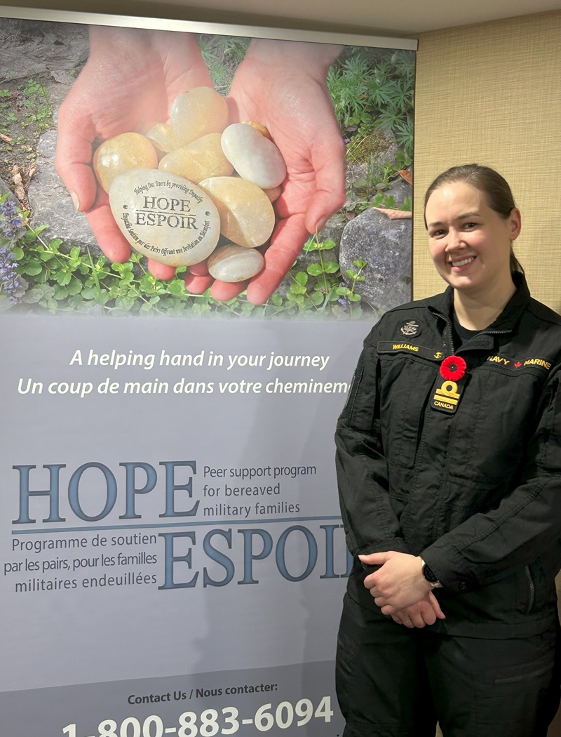 Lieutenant (Navy) Courtney Williams is smiling and wears a navy black uniform with the HOPE banner beside her.