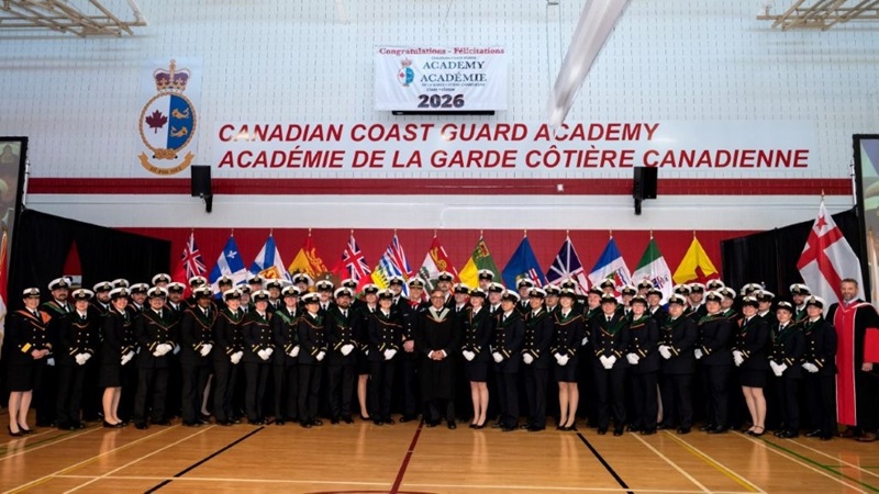 Group of graduates in uniform lined up in the CCG Academy gymnasium.