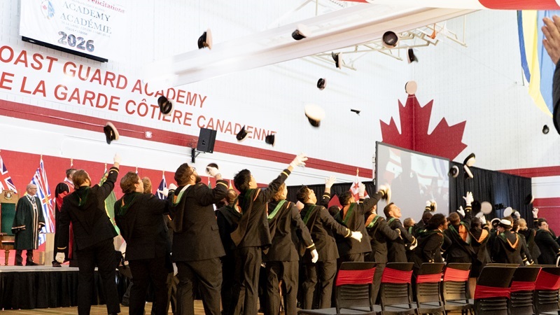 Group of graduates throwing graduation caps in the air.