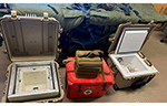 Temperature-controlled medical storage equipment containing blood products is set up beside a patient transport system inside a remote Arctic medical facility.