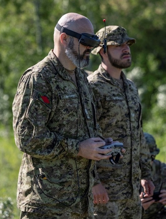 An instructor of the FMUAS Operator Course with goggles on and a remote in their hands demonstrates how to fly an FPV drone.