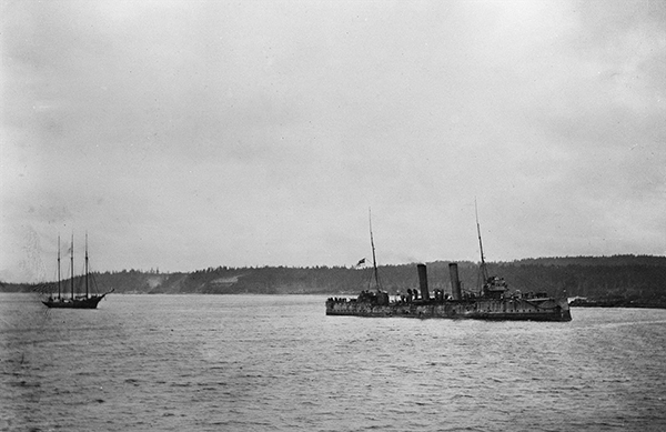 Two ships travel across the water on a cloudy day.