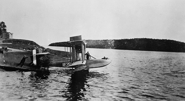 A man pushes a flying boat into the water.