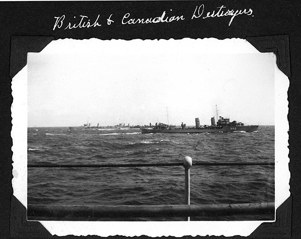 A black and white photograph of a Canadian ship passing a British ship on the water.