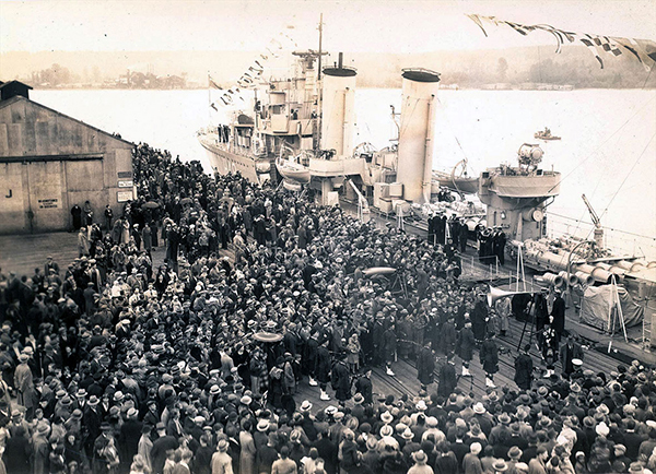 A large crowd of people gather around HMCS Fraser.