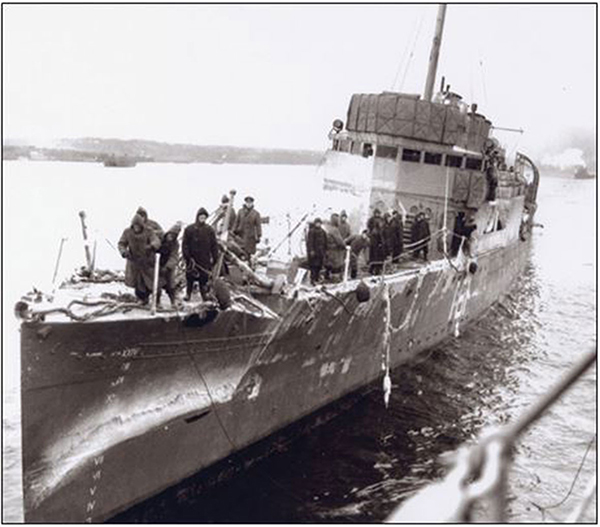 Men stand on a ship’s bow.