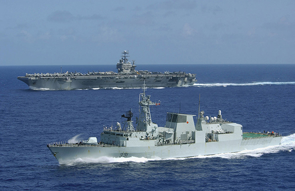 Two ships travel side by side on the water.