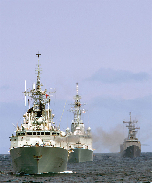 Three ships are seen head-on, travelling in formation.
