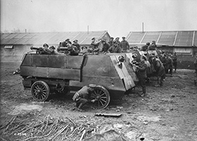 Six armoured cars of the First Canadian Motor Machine Gun Brigade, being cleaned. The nearest vehicle is fitted with two Vickers machine guns. Location unknown. April, 1918.
