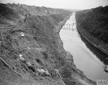 Six armoured cars of the First Canadian Motor Machine Gun Brigade, being cleaned. The nearest vehicle is fitted with two Vickers machine guns. Location unknown. April, 1918.