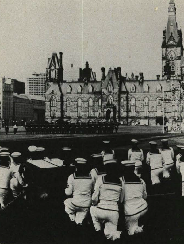 Sailors kneeling in front of the Parliament Building.