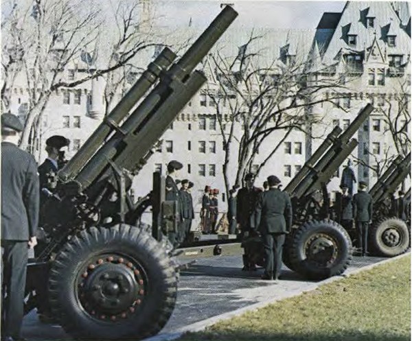 Soldiers at attention, with canons, in front of the Parliament buildings.