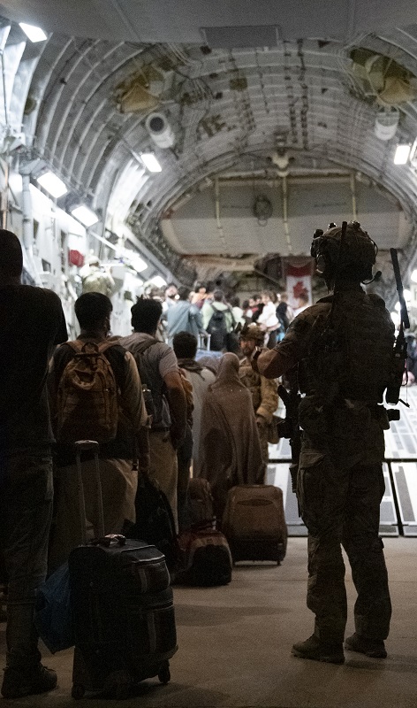 Des membres des Forces armées canadiennes aident au transport des évacués de Kaboul, en Afghanistan, vers le Canada dans le cadre de l'Op AEGIS, le 23 août 2021 à Kaboul, en Afghanistan. Photo par : Caporal Natasha Punt, Forces armées canadiennes.
