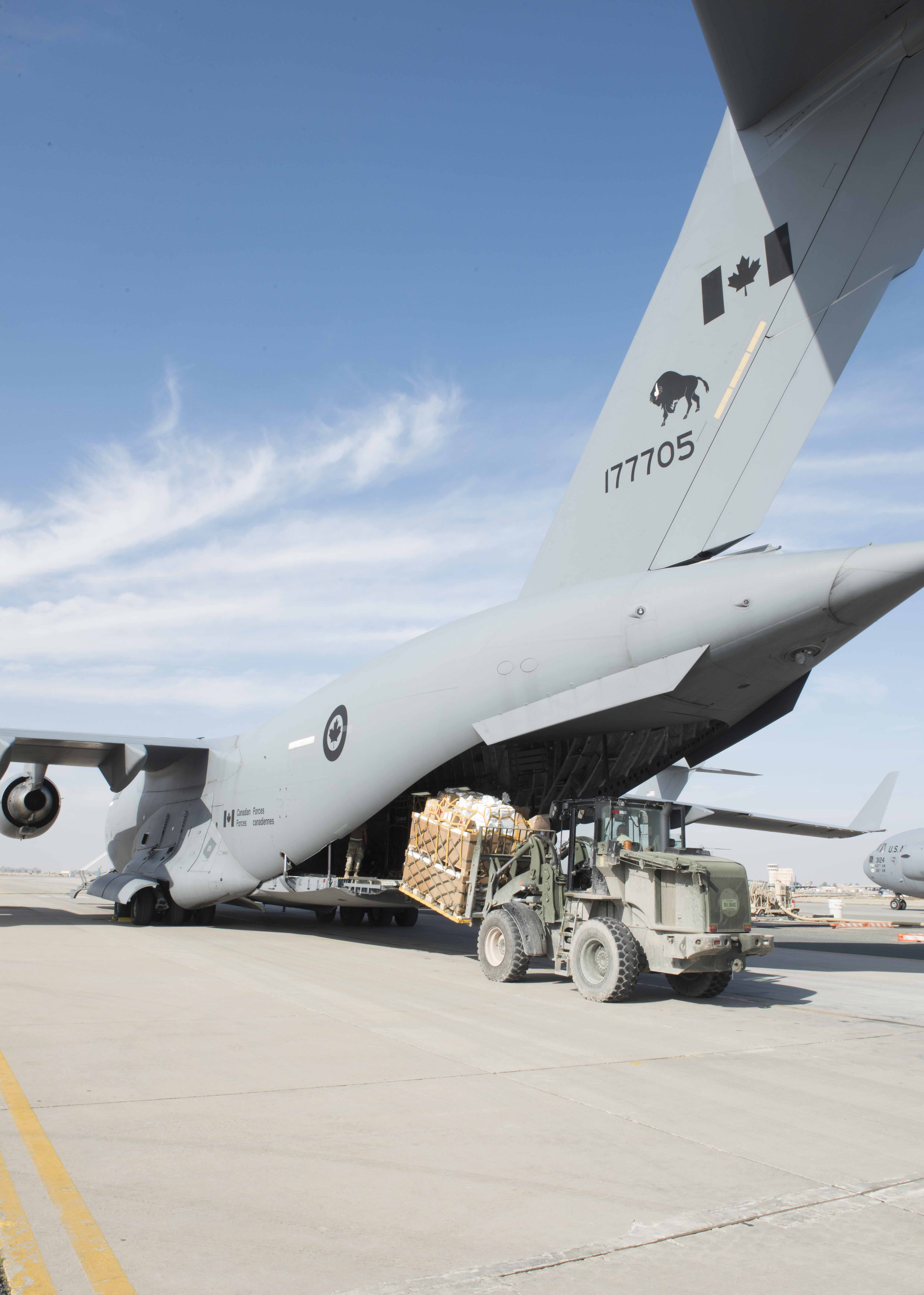 A coalition member removes a pallet from a Canadian Forces CC-177 sustainment flight at Ali Al Salem Air Base, November 26, 2018. Image by:  Op IMPACT Imaging