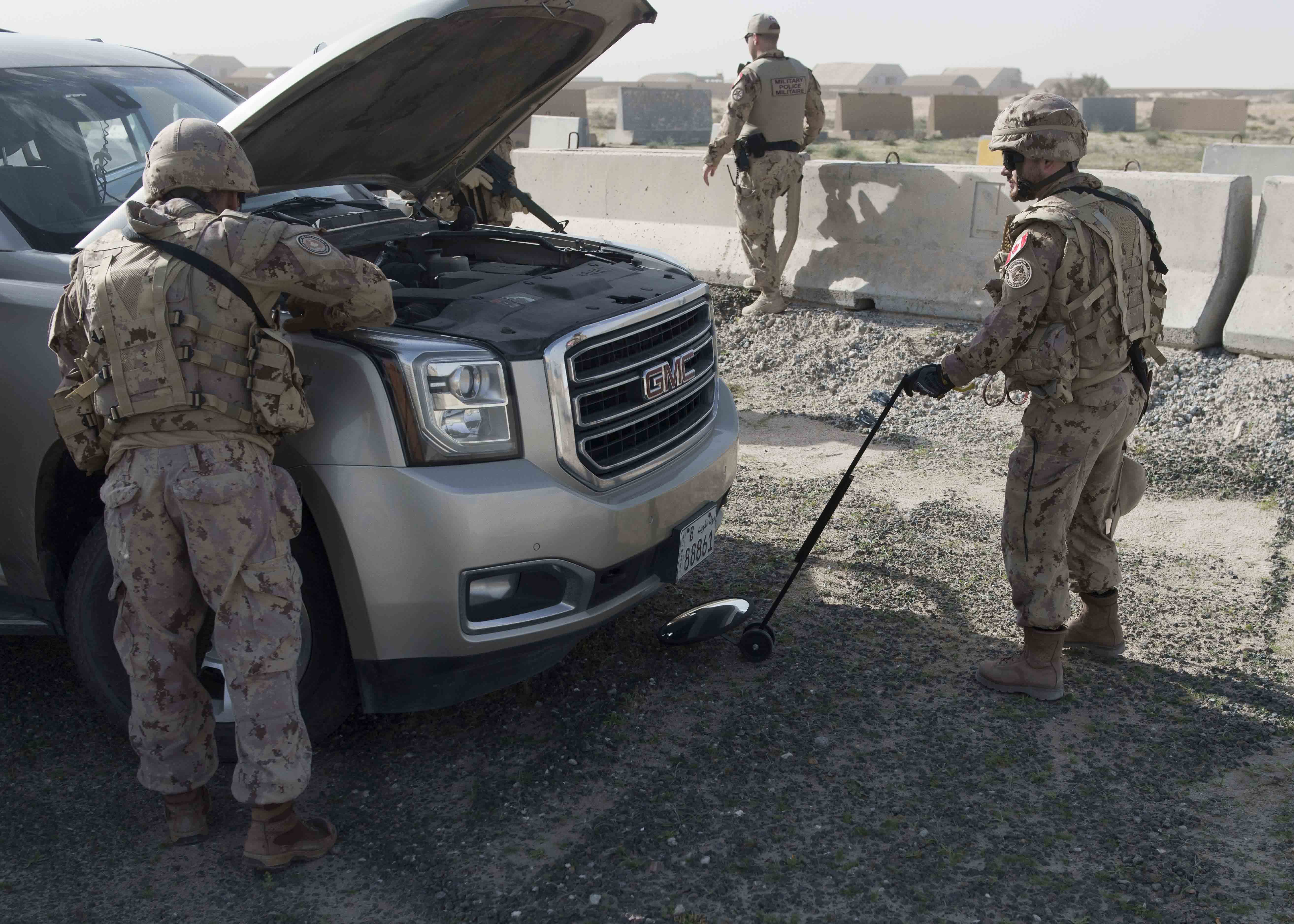 Des membres de la Force auxiliaire de sécurité  de la Force opérationnelle interarmées en Irak fouillent un véhicule suspect, durant un exercice au Camp Canada, le 21 décembre 2018. Photo : Services d’imagerie de l’Op IMPACT