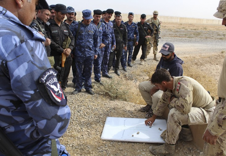 Les membres des Forces de sécurité irakiennes faisant partie de la deuxième vague de stagiaires se font expliquer la recherche de mines sur un tableau blanc par un instructeur des Forces armées canadiennes, à Q-Ouest, en Irak, le 22 octobre 2018. Photo : Services d’imagerie de l’Op IMPACT
