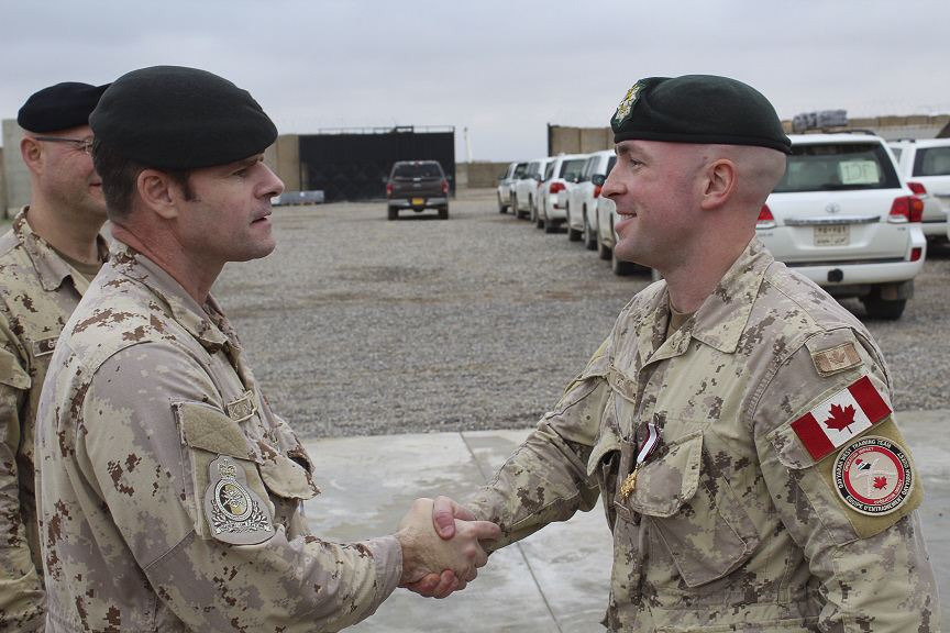 Lieutenant-General Michael Rouleau, Commander of Canadian Joint Operations Command, presents Captain Michael Hobb, Q-West administration officer, with his service medal at the completion of a six-month deployment with JTF-Iraq on 25 November 2018. Image by:  Op IMPACT Imaging