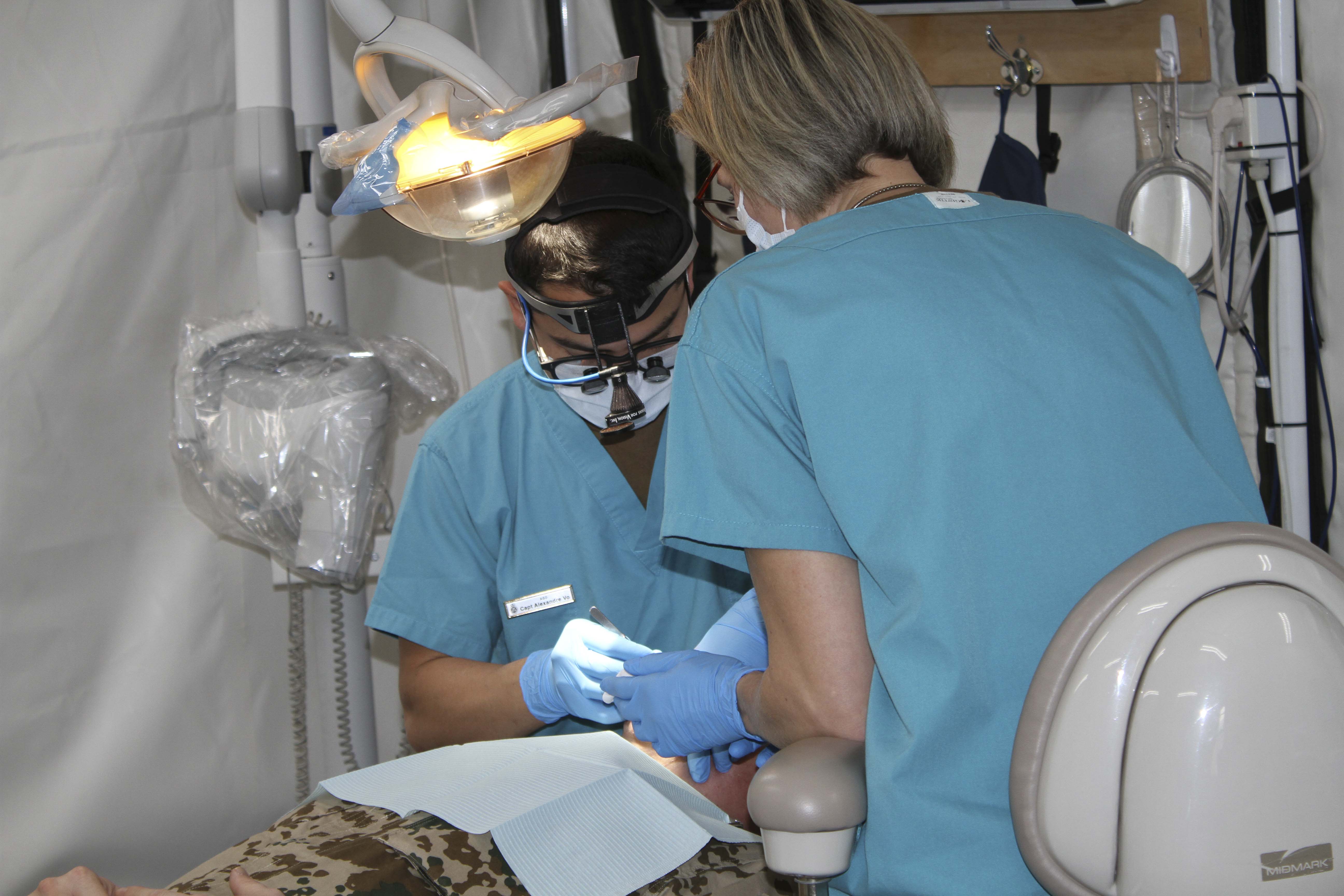 Canadian Armed Forces (CAF) dental officer Captain Huy-Bao Vo (Left) and CAF dental technician Sergeant Wendy Krause provide dental care at Joint Task Force –Iraq’s Role 2 Hospital in Erbil Iraq in early January 2019. Image by:  Op IMPACT Imaging
