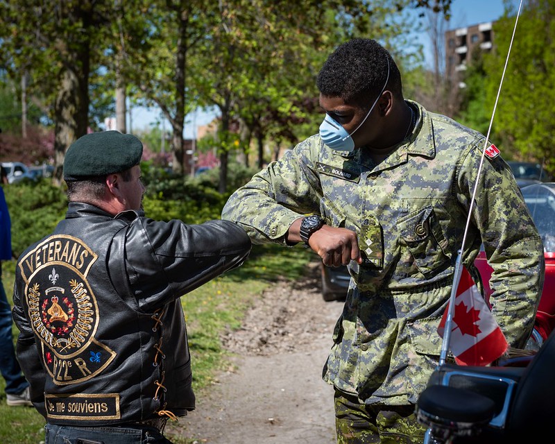 A Royal 22e Régiment veteran (left) and Lieutenant Adolph Bolivard (right), an infantry officer from 4th Battalion, Royal 22e Régiment (Châteauguay), greet each other at the Centre d'hébergement Yvon-Brunet during Operation LASER, in Montreal, Quebec, on 23 May 2020.
