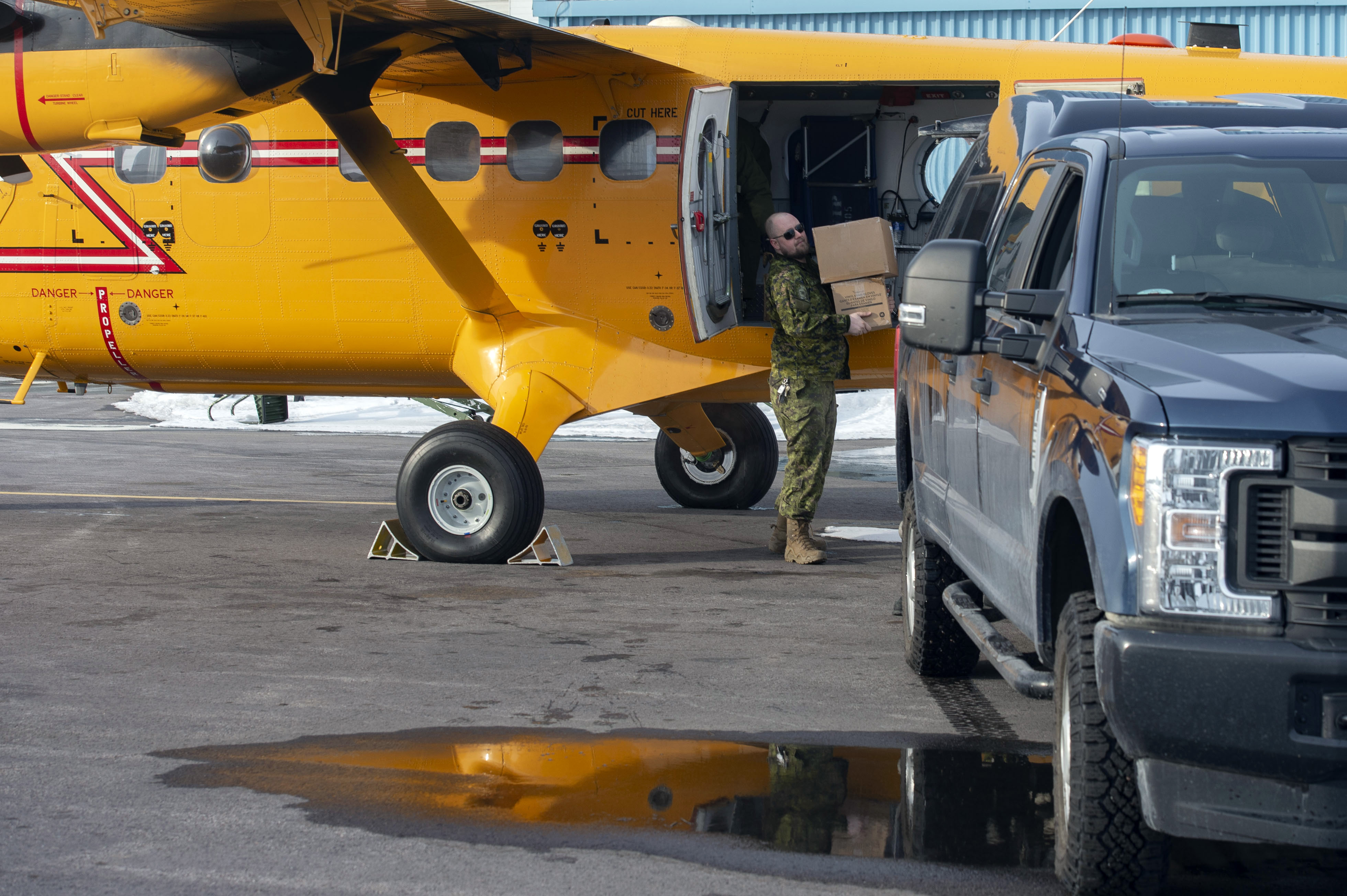 A Traffic Technician with Area Support Unit (North), unloads a CC-138 Twin Otter's cargo load of personal protective equipment destined to northern communities at 440 (Transport) Squadron in Yellowknife, Northwest Territories on April 15, 2020 as part of Operation LASER.