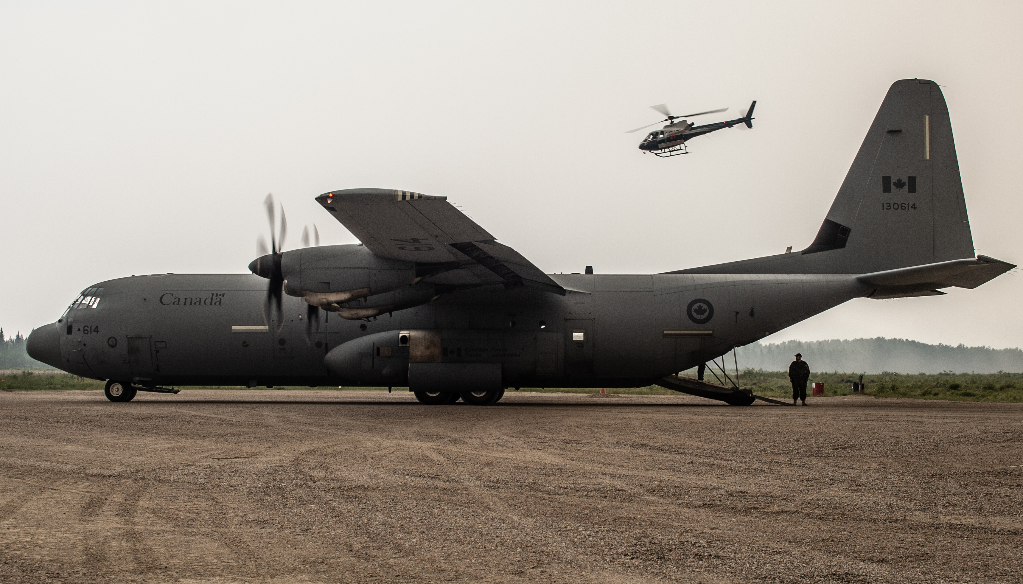 Des membres des Rangers canadiens de Armée canadienne et l’équipage aérien d’un CC-130J Hercules de Aviation royale canadienne travaillent fort pour aider à évacuer les membres vulnérables de la collectivité de la Première Nation Pikangikum dans le Nord Ouest de l’Ontario le 6 juillet 2019.