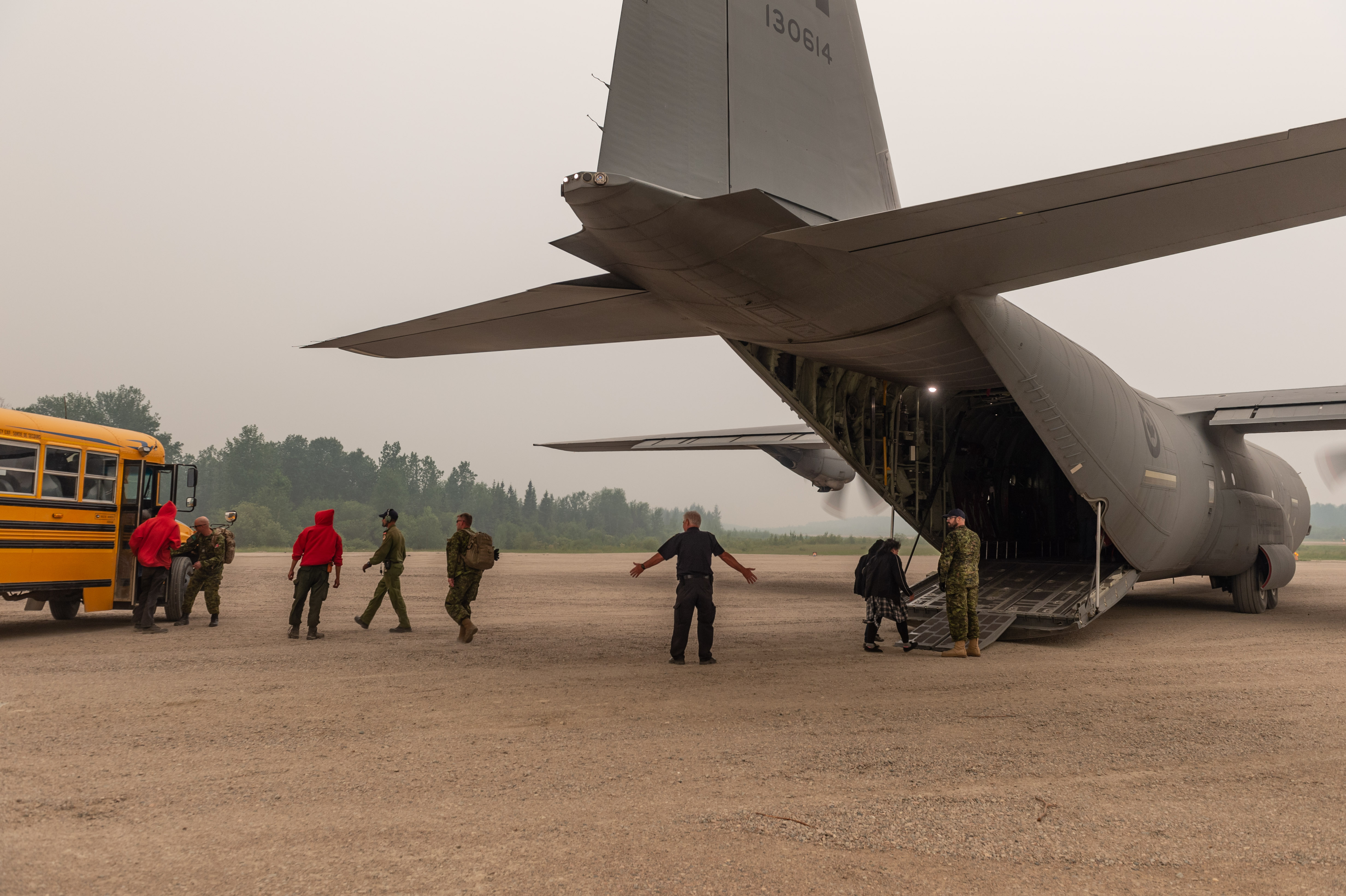 Des membres des Rangers canadiens de Armée canadienne et l’équipage aérien d’un CC-130J Hercules de Aviation royale canadienne travaillent fort pour aider à évacuer les membres vulnérables de la collectivité de la Première Nation Pikangikum dans le Nord Ouest de l’Ontario le 6 juillet 2019.