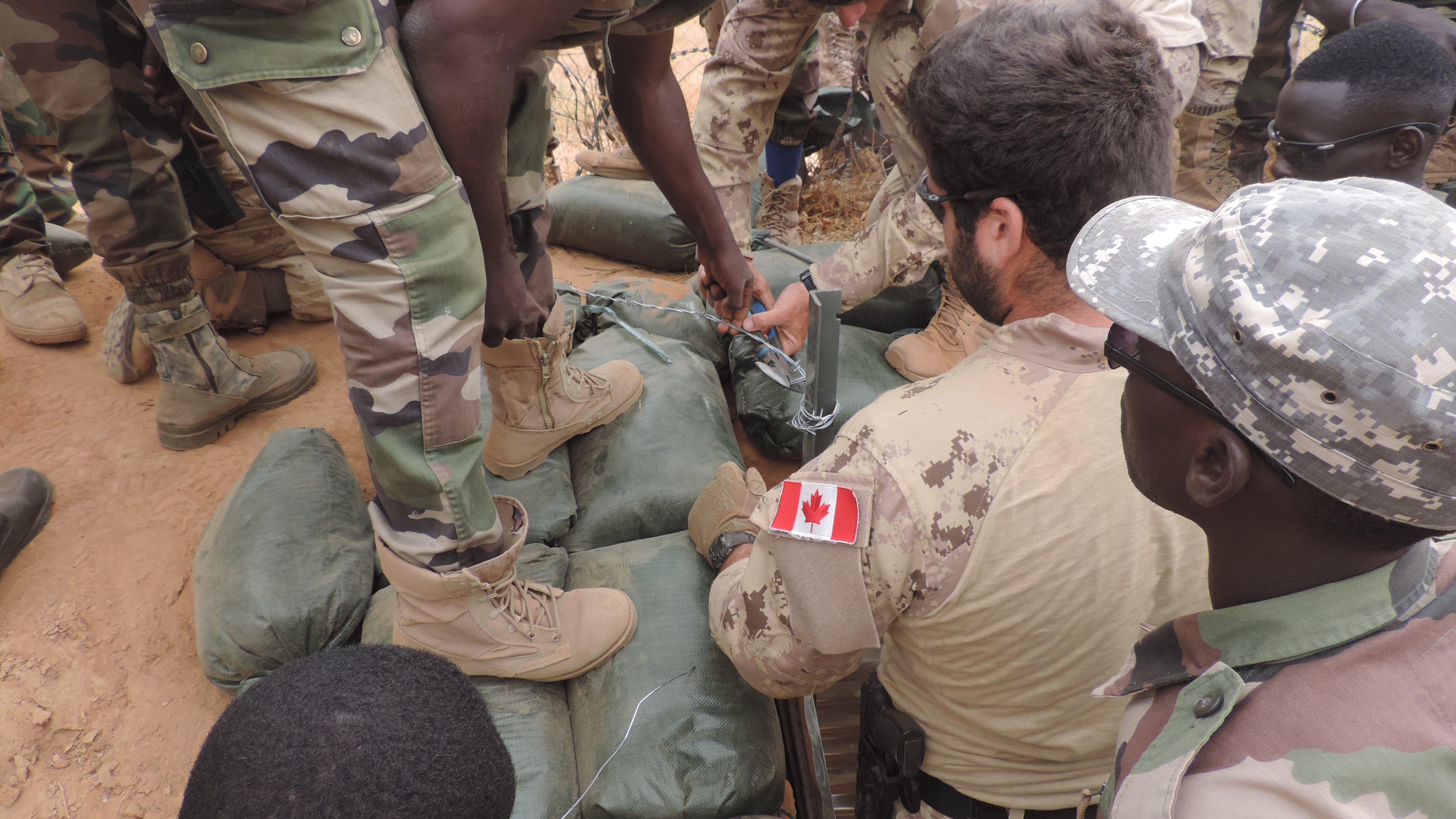 Un membre des Forces armées canadiennes encadre des membres des Forces armées nigériennes qui creusent des tranchées pendant l’opération NABERIUS 2017 au Niger. (Photo : Op NABERIUS 201702)