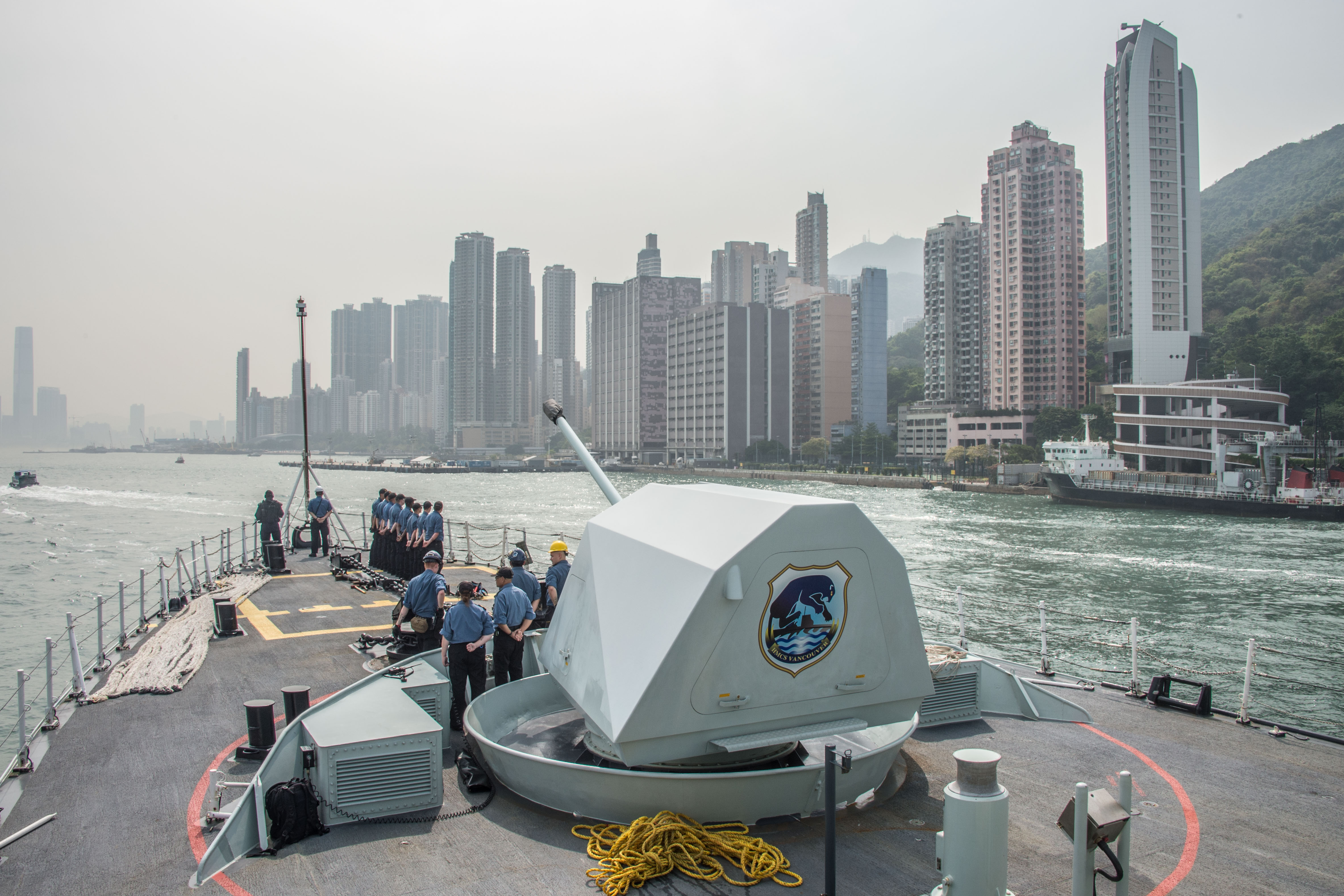 Le Navire canadien de Sa Majesté (NCSM) VANCOUVER approche du port de Hong Kong au cours de l’opération PROJECTION dans la région Indo Asie Pacifique, le 3 mai 2018. Photo : Caporal chef Brent Kenny, Services d’imagerie des FMAR(P) ET01-2018-0150-037