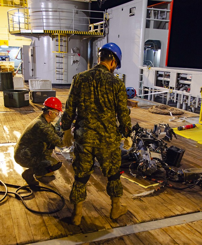 Canadian Armed Forces members inspect recovered parts of Stalker 22 during recovery operations for the aircraft in the Mediterranean Sea on 31 May 2020.