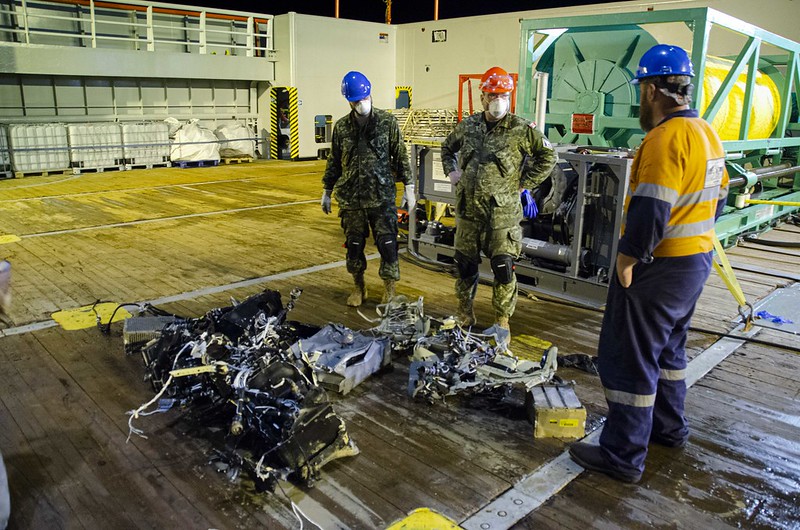 Canadian Armed Forces members and EDT Hercules personnel inspect recovered parts of Stalker 22 during recovery operations for the aircraft in the Mediterranean Sea on 31 May 2020.