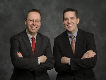 Eric Fournier and Chris Brosinsky, side by side, arms folded.